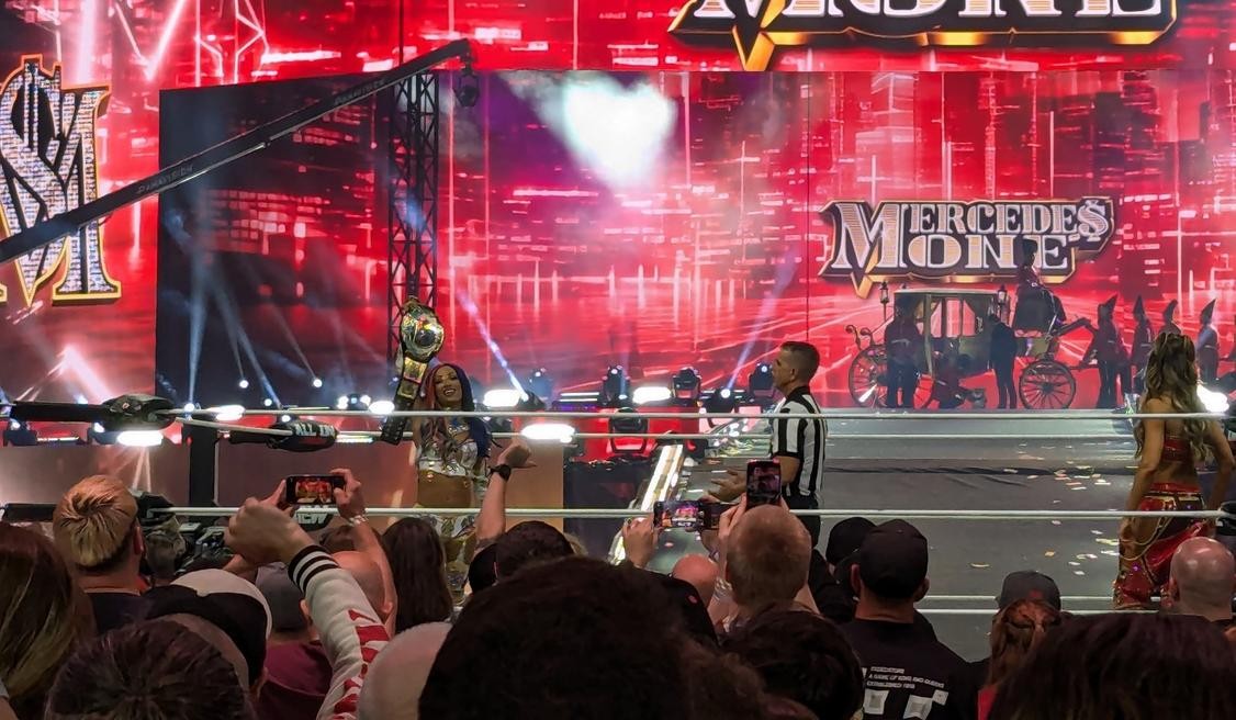 Mercedes Moné holds the AEW TBS Title aloft as Britt Baker looks on