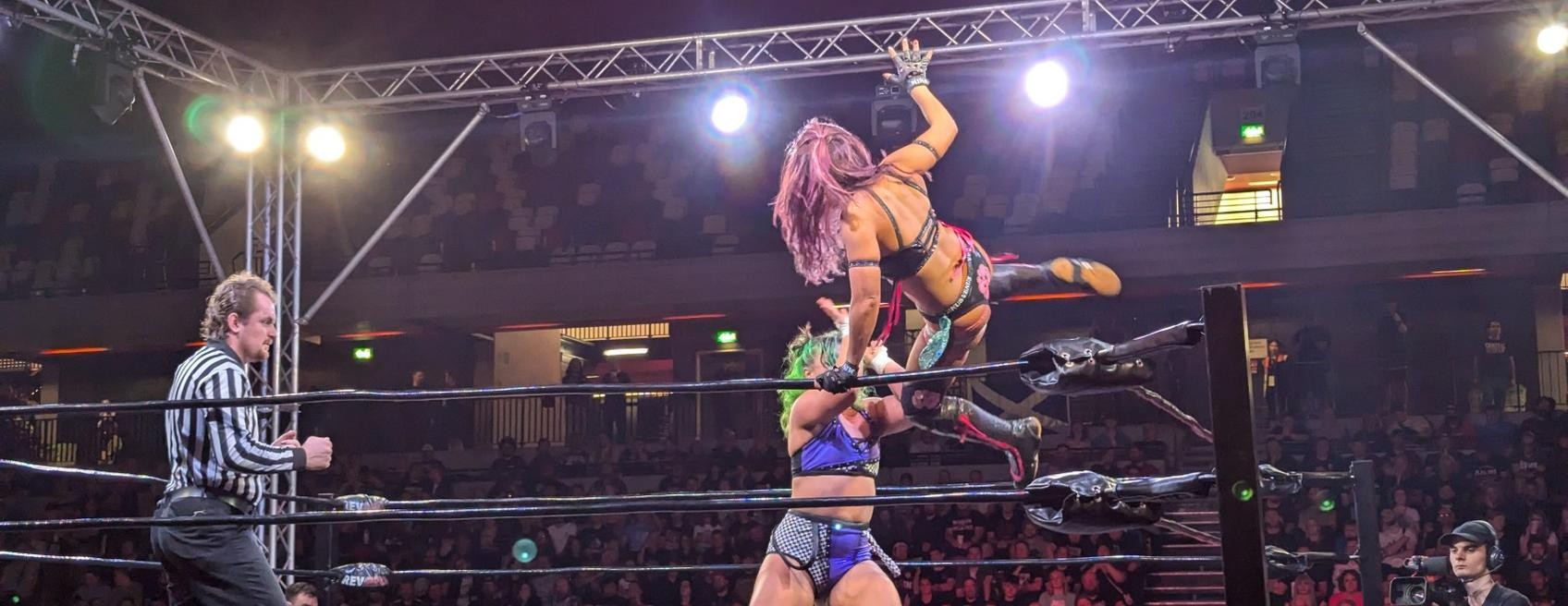 Mina Shirakawa leaping at Dani Luna from the turnbuckle