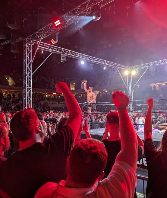 Luke Jacobs celebrates winning the RevPro Undisputed British Heavyweight Title as the crowd erupts